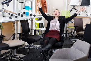 female testing a chair in an used office chairs dealer showroom
