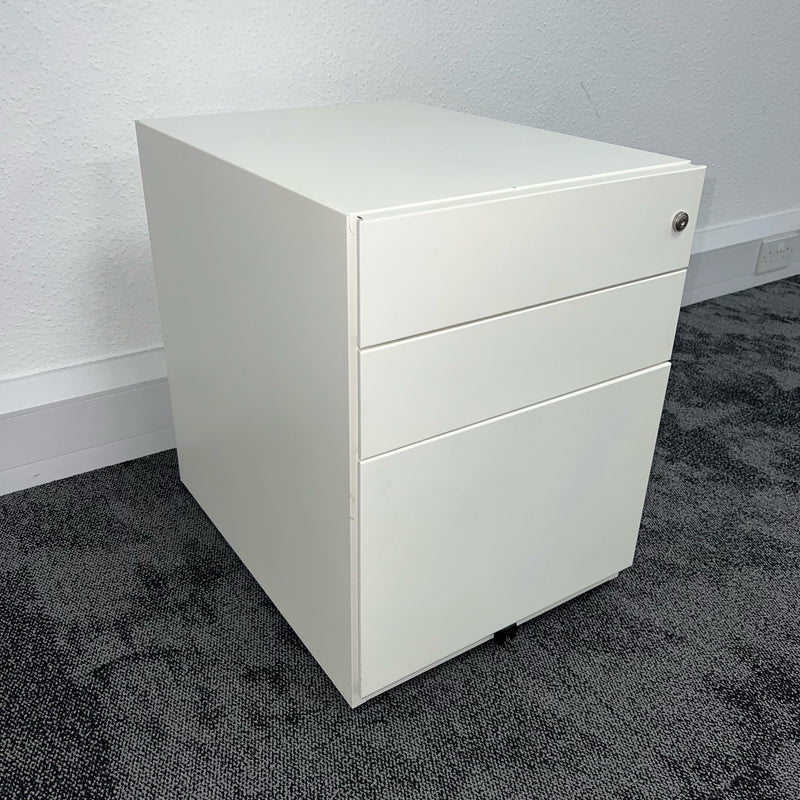 white office pedestal with three drawers on grey carpet with white wall in the background